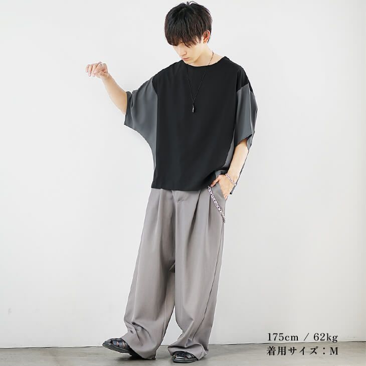 ブラックドルマントップスとグレージュパンツのストリートコーデ