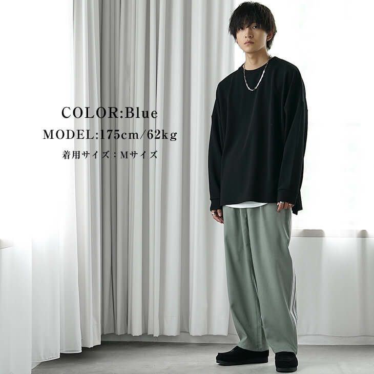 黒トップスとくすみブルーパンツのワントーンストリートスタイル